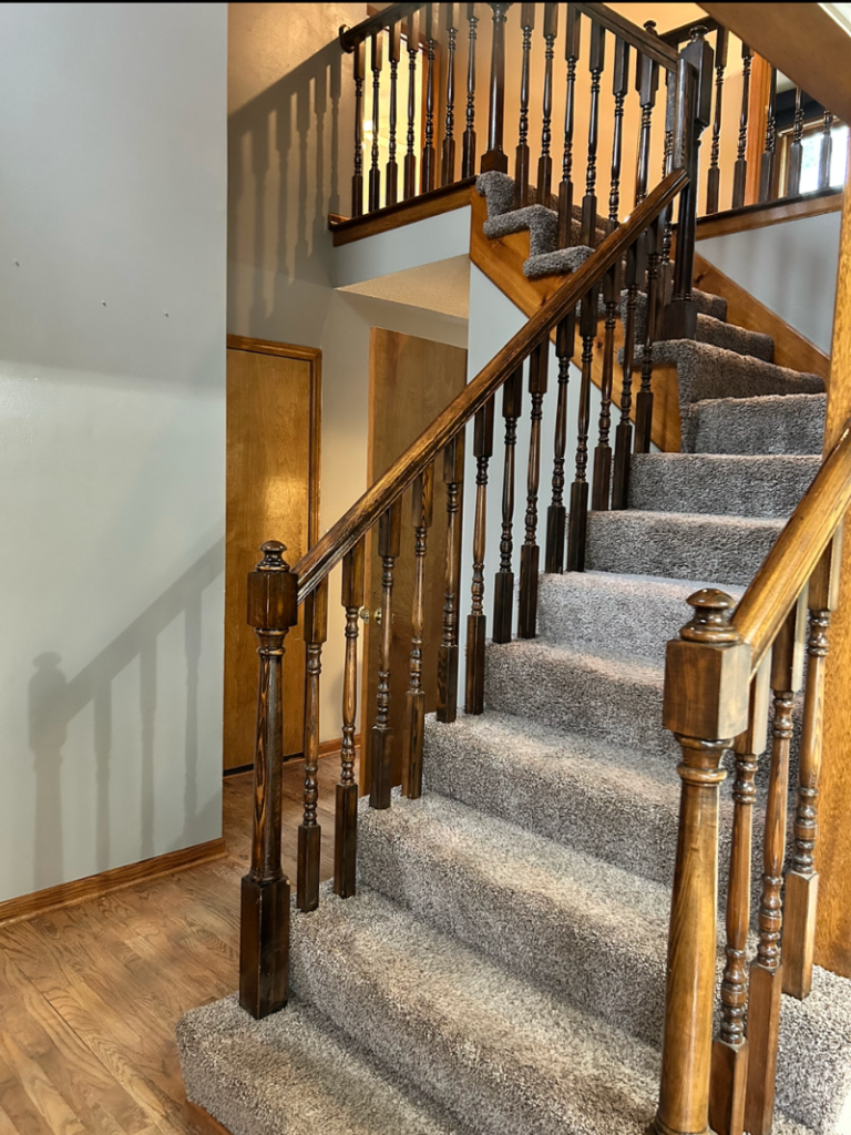 staircase with wood trim and carpet