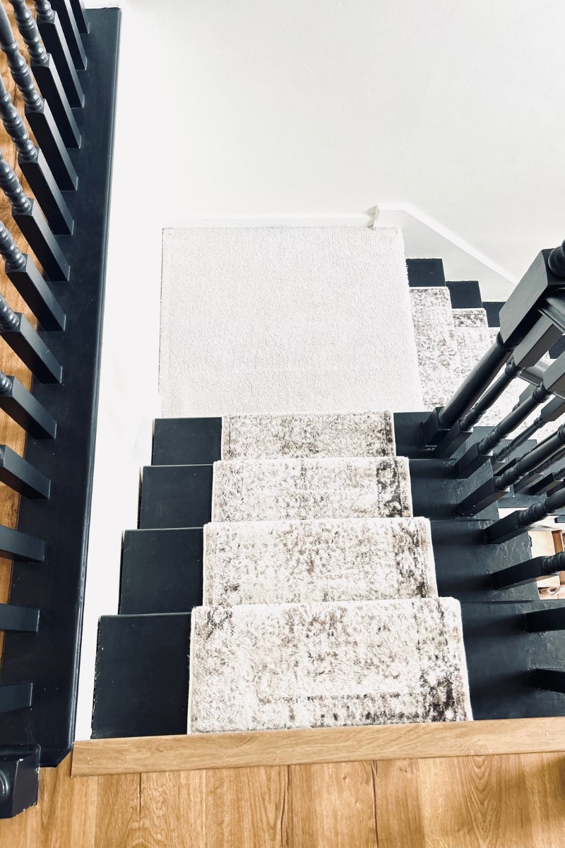 black painted stairs with runner