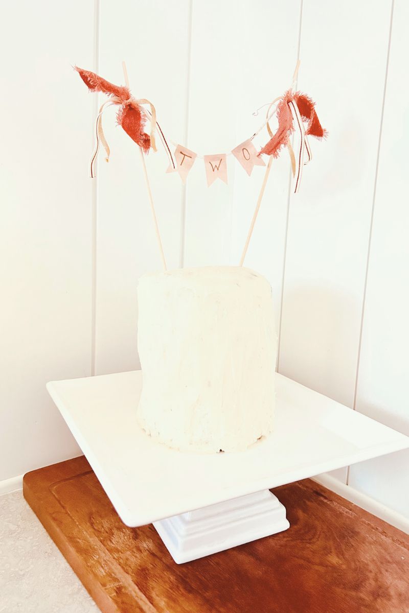 DIY cake topper on white tiered cake